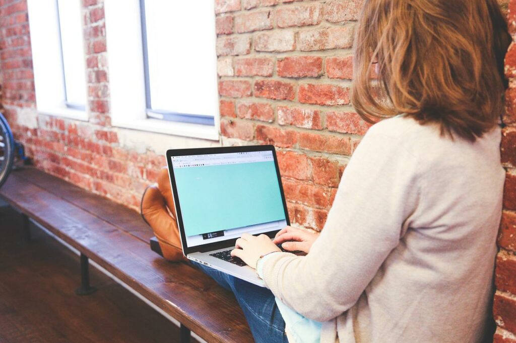 Frau tippt und arbeitet am Laptop Als Freelancer Geld verdienen Ideen für den Start