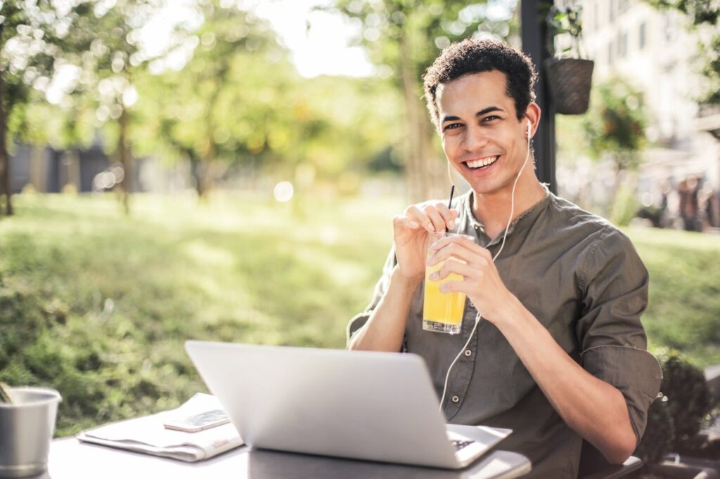 Mann Laptop draußen glücklich Sonne Wie viel verdienen SEO-Manager – Ein Überblick über Gehalt, Einflussfaktoren und Karrierechancen